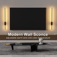 Modern wall sconces on a wall with a television and coffee table in the foreground.