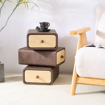 Wooden nightstand with drawers next to a bed in a bedroom setting