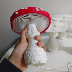 Red mushroom night light glowing on a wooden bedside table